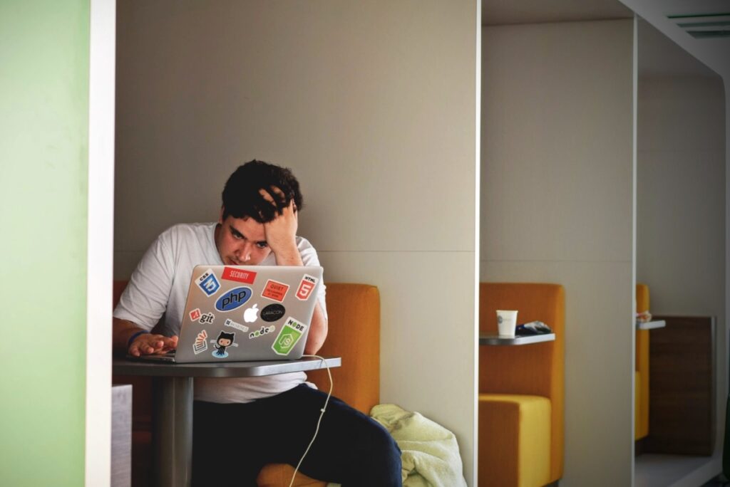 student sitting down looking at his laptop worry