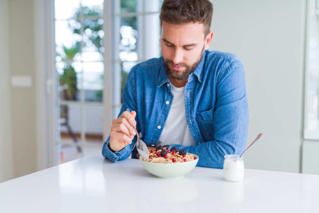 young man eating oats or breakfast