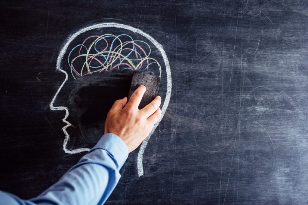 drawing of a human head in a black board beign erased