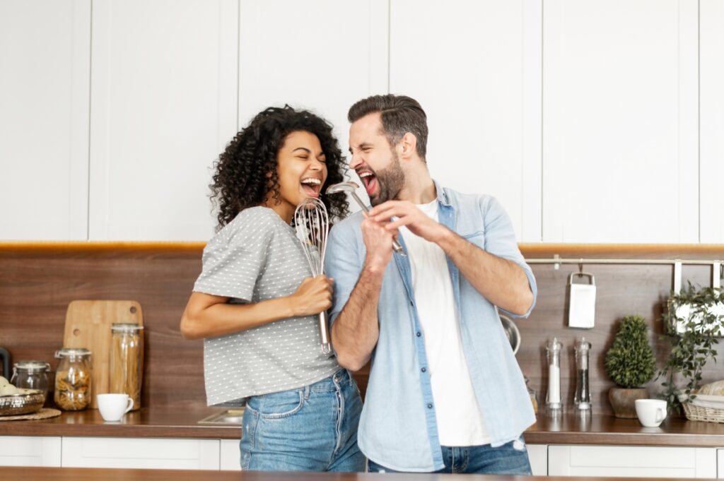 couple in the kitchen singing with kitchenware