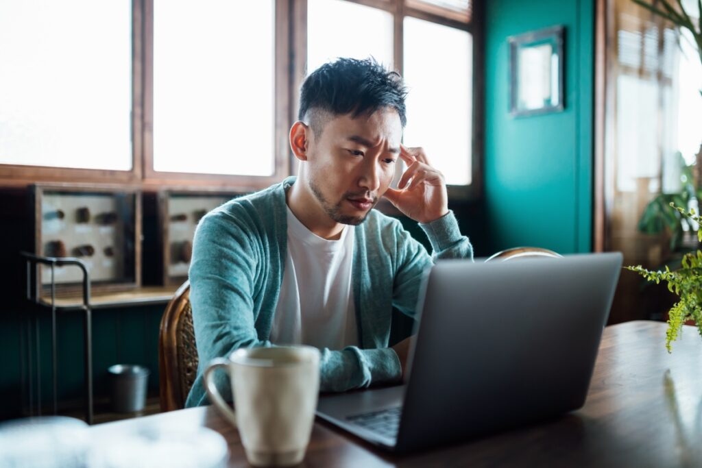 man stressed looking at his laptop