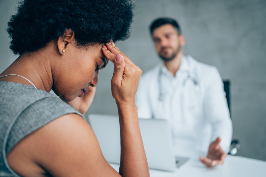 A female stressed patient and a male doctor meet in a medical clinic