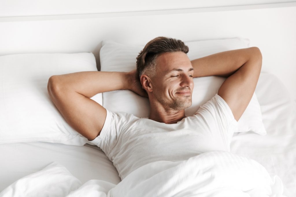 man relaxing in bed and looking away