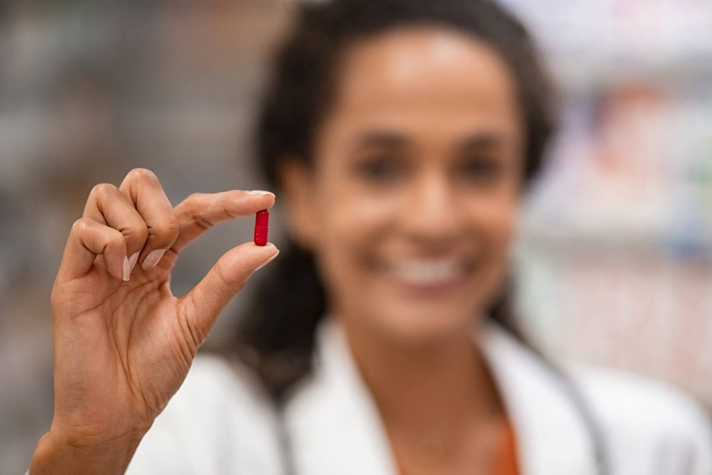  Smiling  woman pharmacist holding medicine.