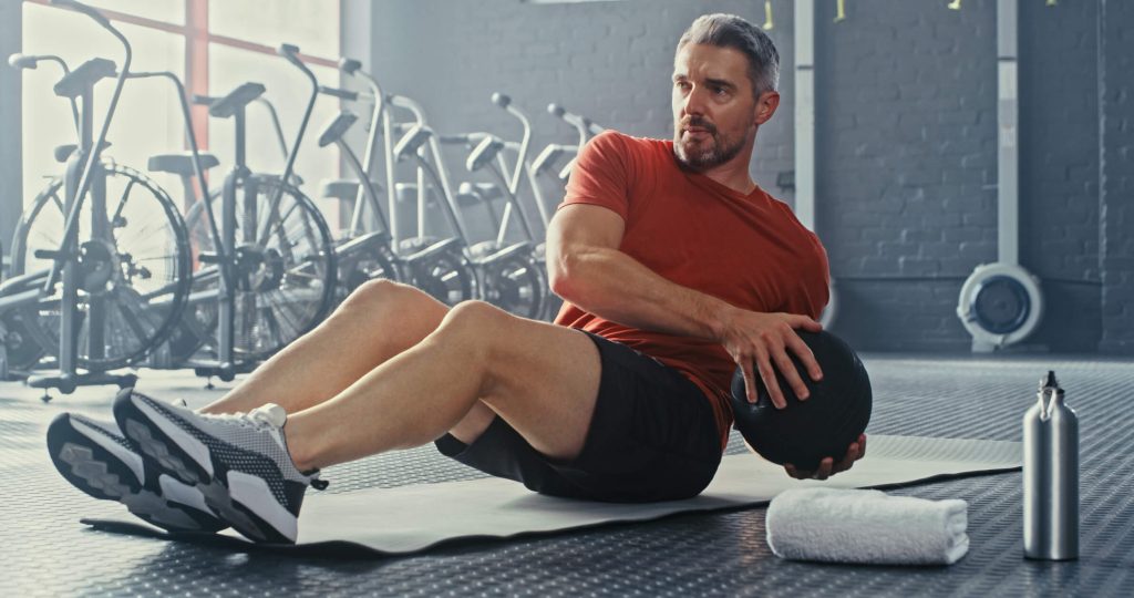 Shot of a man using a medicine ball during his workout in the gym