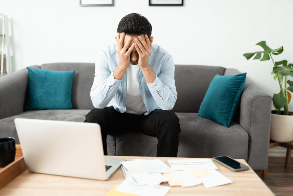 man sitting with his hands over his head 